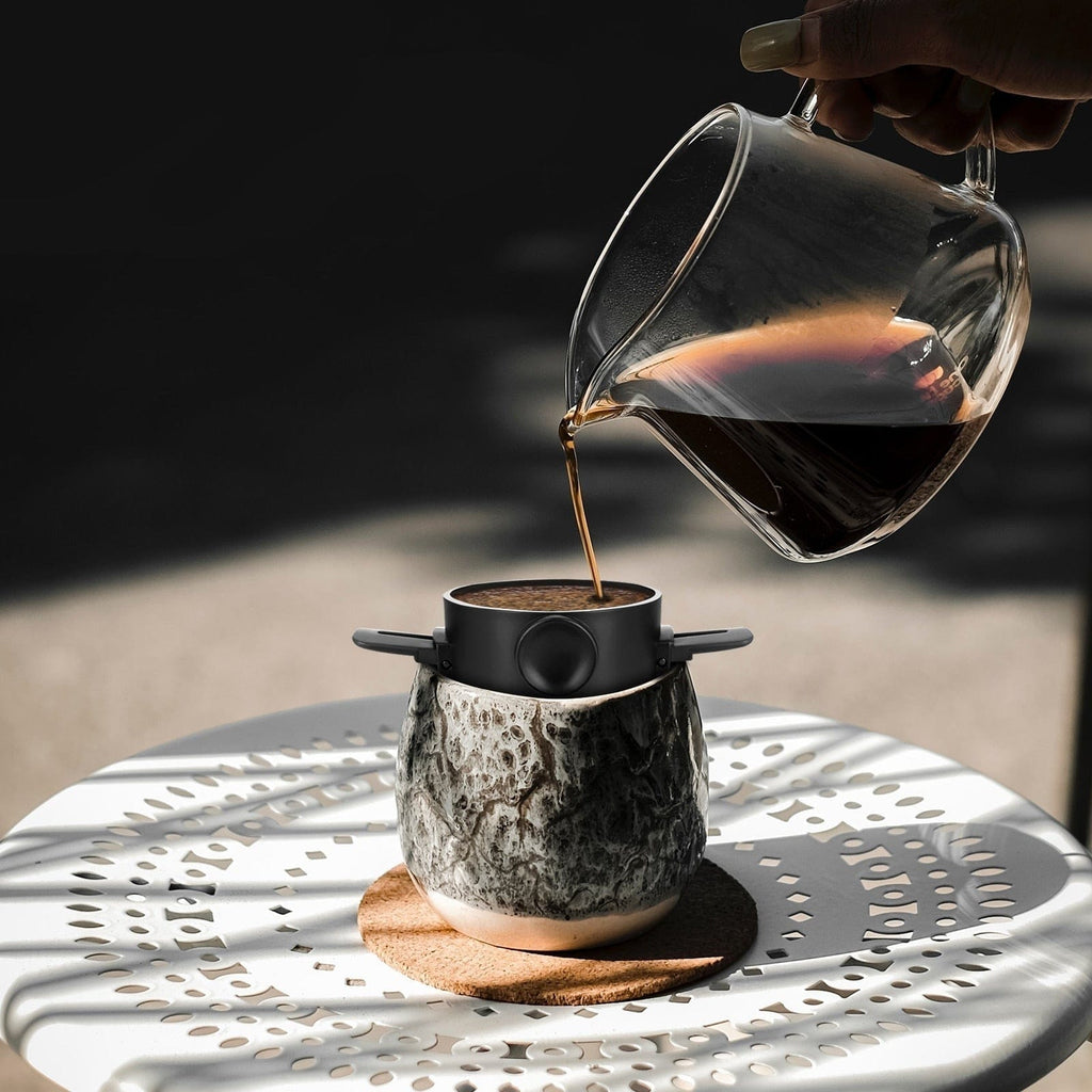 Pouring coffee into the Portable Coffee Maker for travel.